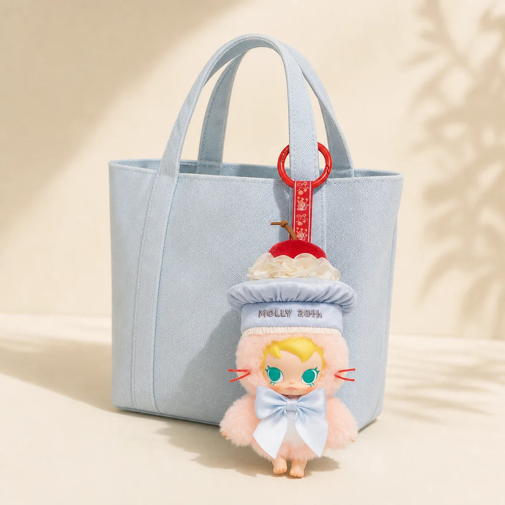 Baby Molly 20th Anniversary Vinyl Plush Doll attached to a light blue bag