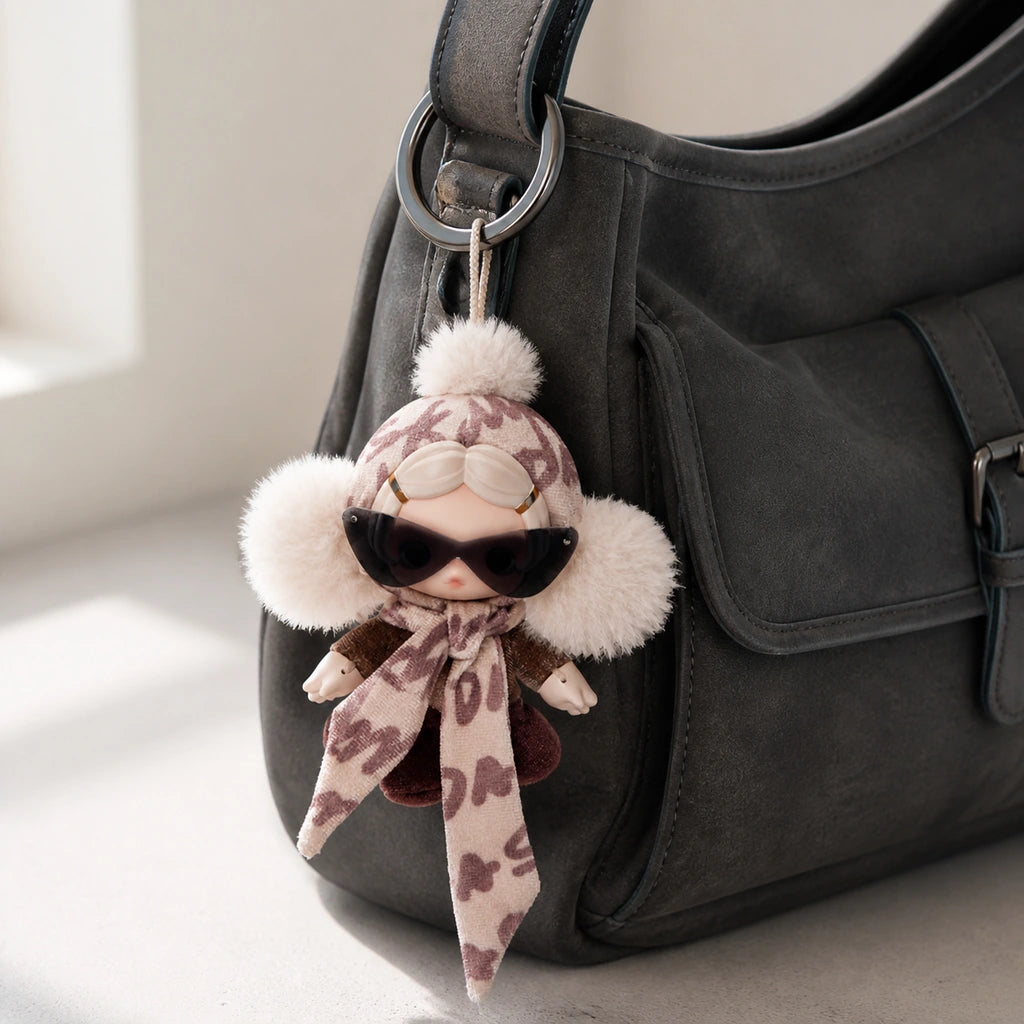 SKULLPANDA Off Mode plush pendant attached to a charcoal shoulder bag