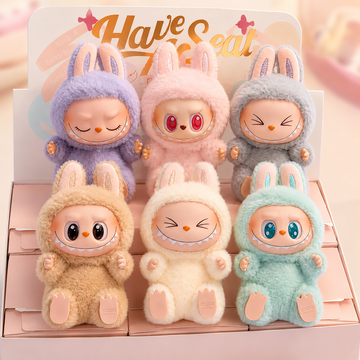 Set of six plush toys in colorful bunny costumes on a pink background with 'Have Seat' text.