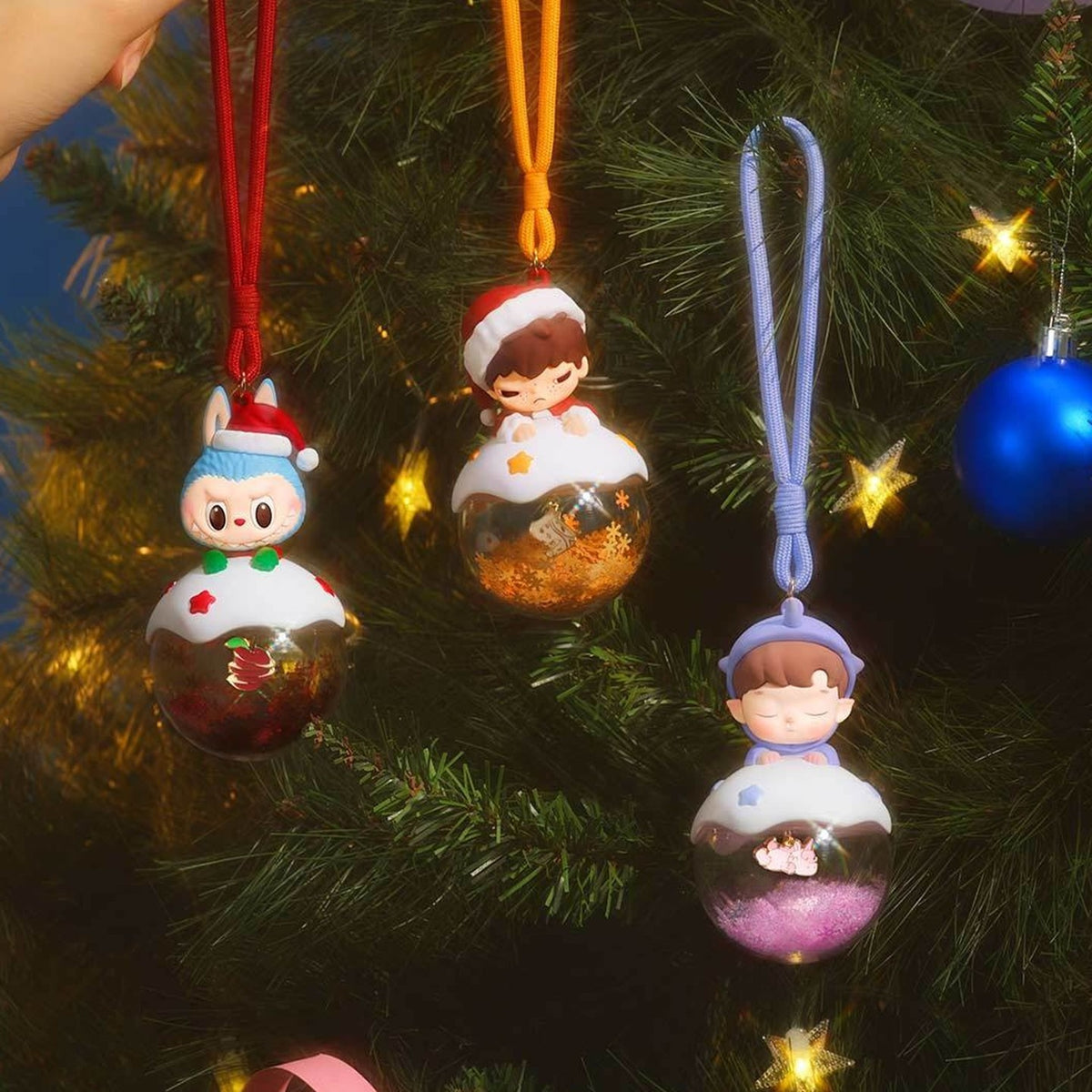 Apple of My Eye luminous pendant design examples hanging on a tree; scene props and all pictured designs are not guaranteed box contents
