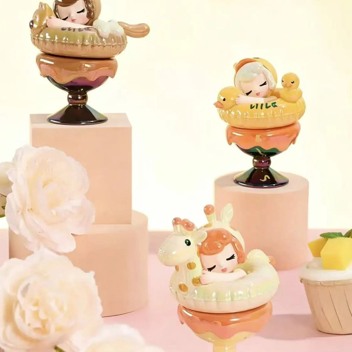 Dessert-themed figure examples on display plinths; designs shown are illustrative