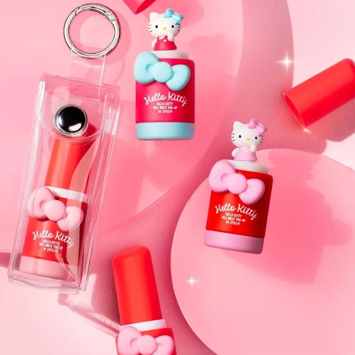 Blue and pink Hello Kitty miniature design examples beside clear display props; props are not promised as included