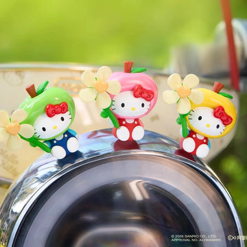 Three fruit-costume Hello Kitty figure design examples with flower-shaped details; pictured group is not supplied contents