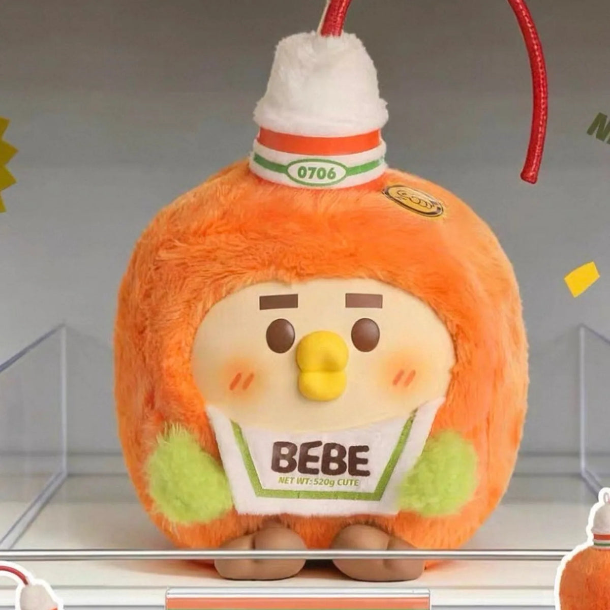 Little Parrot BEBE Foodie Club orange bottle-costume plush face, BEBE label and cord detail; series example