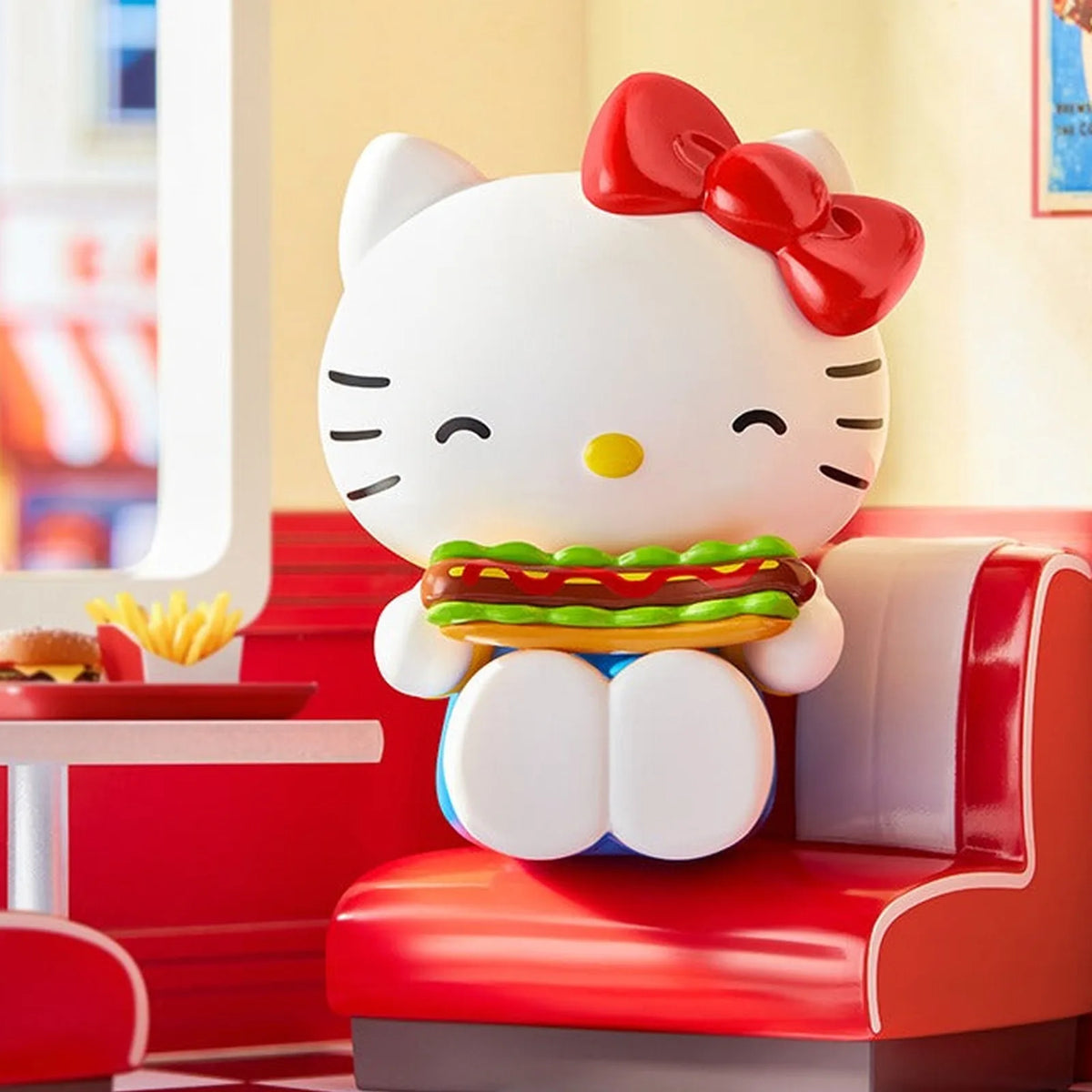 Hello Kitty seated on a red diner seat holding a hot dog; exact series reference, random purchase does not guarantee pictured design