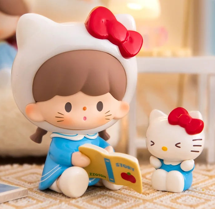 Complete seated white-cat-hood figure design example with full ears, red bow, face, book and seated outline; small matching character beside it; random design not guaranteed; random purchases do not guarantee this design