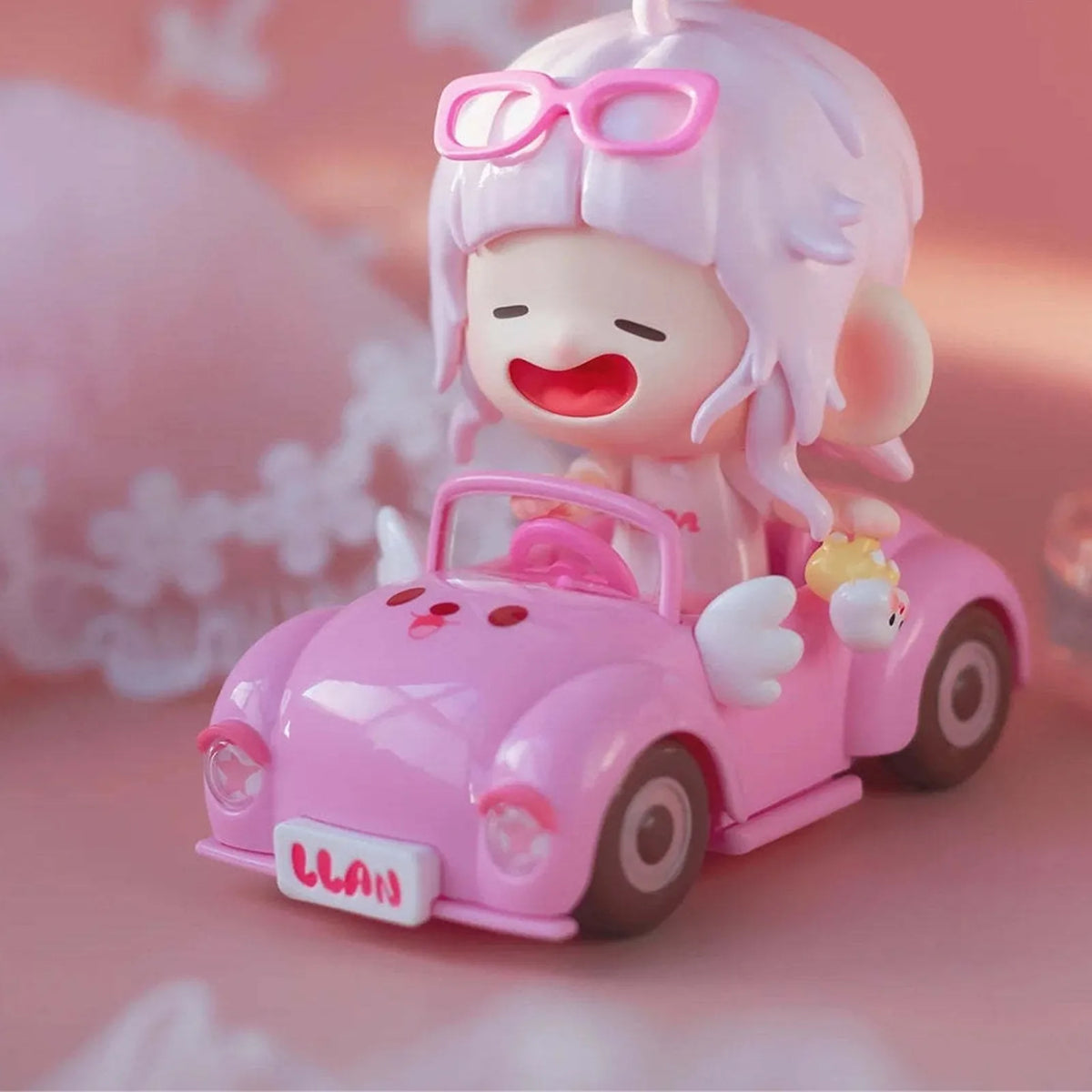 Pink Dream figure with pink glasses in a pink car; photographed design example, not guaranteed