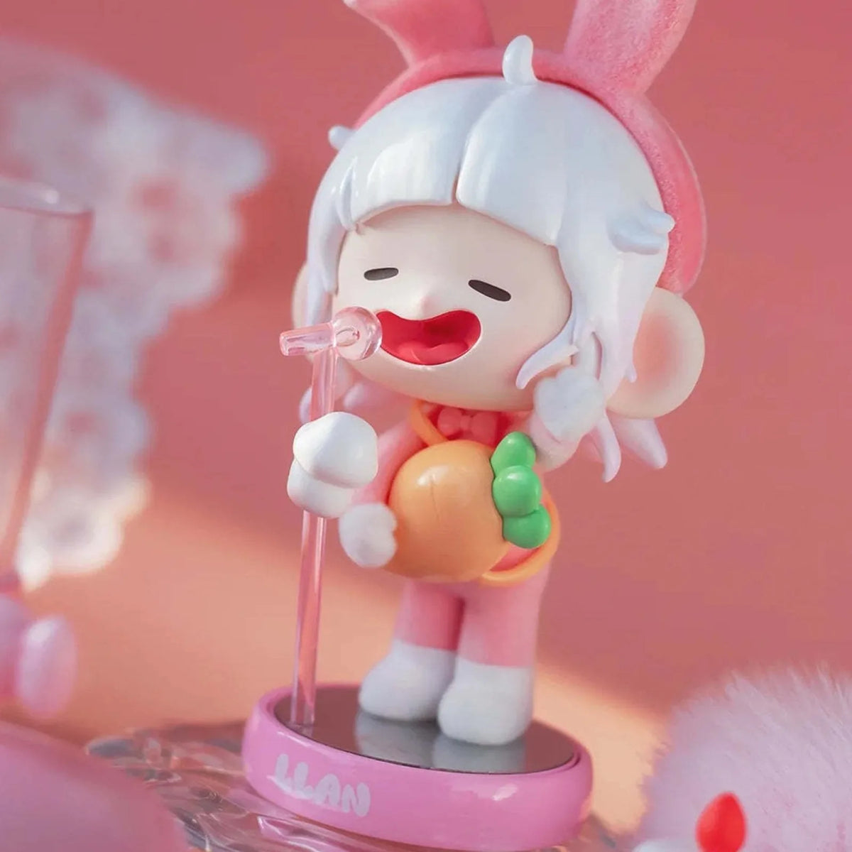 Pink Dream rabbit-ear figure with carrot details; photographed design example, not guaranteed