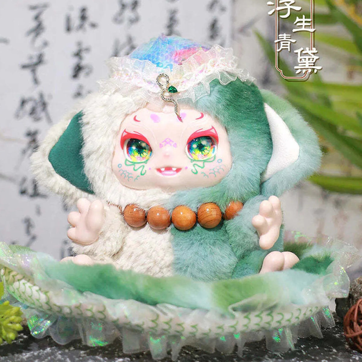 KIMMON plush in a pale green costume with bead-like details; series design example | KikiBuddies