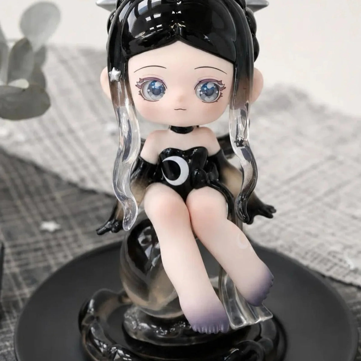 Black-haired Lukiss character with a crescent detail in a dark outfit; physical series reference, random purchase does not guarantee this character