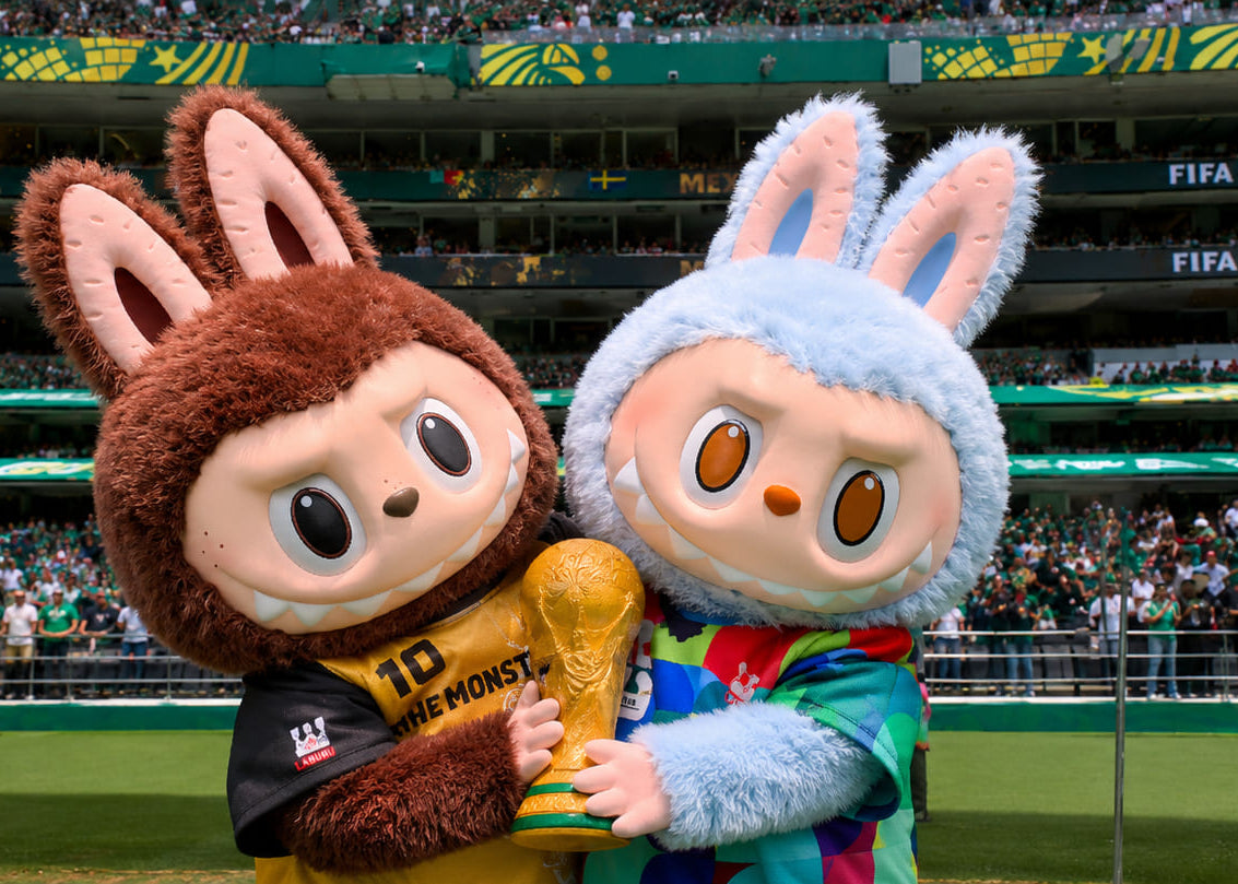 Two cartoon characters holding a trophy on a sports field with 'FIFA World Cup' branding.slider_item_MJXHxW