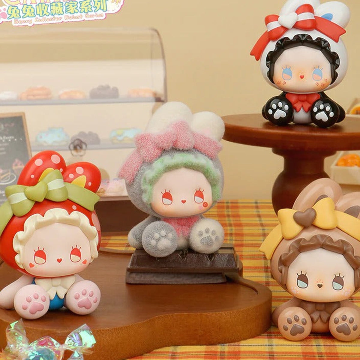 EMMA Bunny Collector Debut four possible figure designs in a styled scene, including black, red, grey and brown hoods; no specific design guaranteed