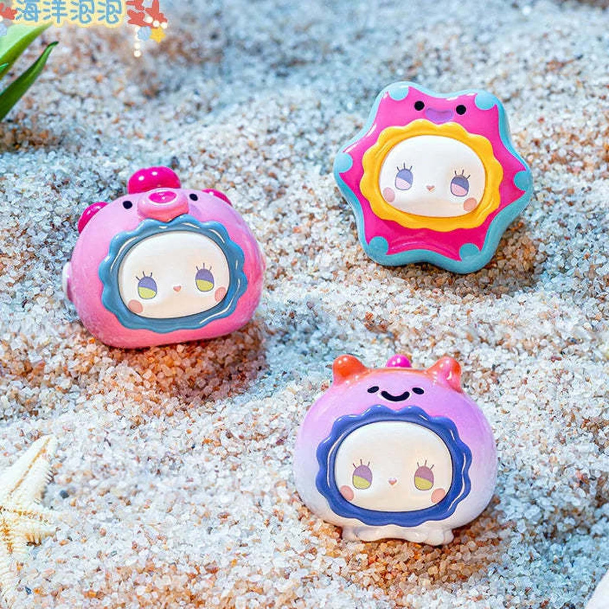 EMMA Ocean Bubble Series Mini Blind Box - Complete ocean-themed mini figure examples on sand; pictured design not guaranteed