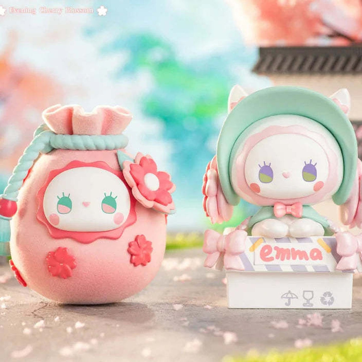 EMMA Secret Forest Cherry Blossom Series Blind Box - Complete figure comparison with pink floral and green outfit examples; random design not guaranteed