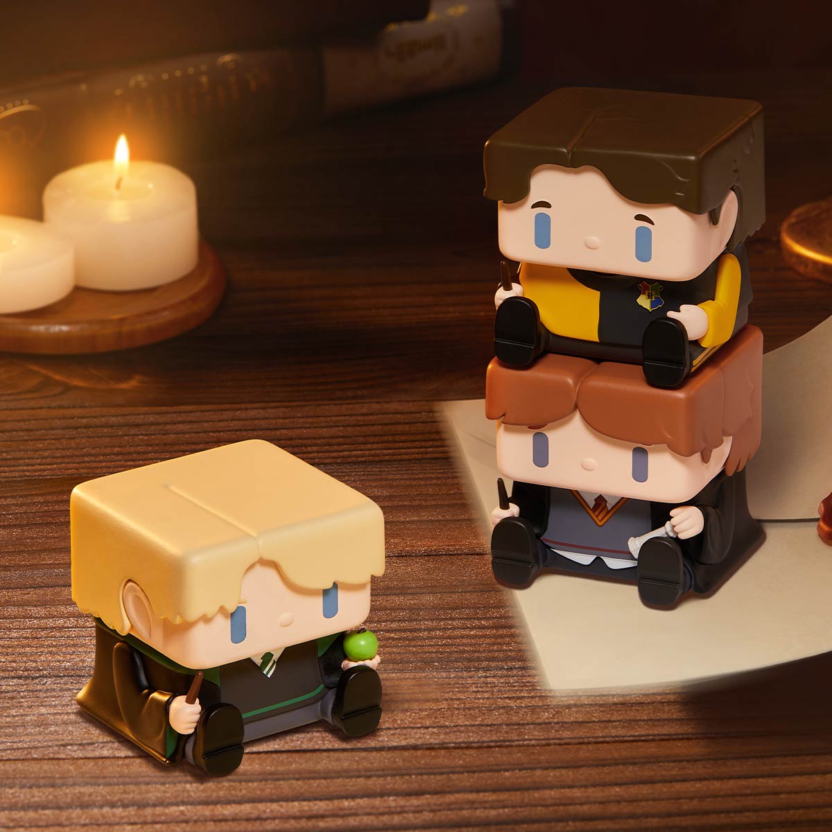 POP CUBE-2 figure examples beside a book and candles; random designs, display props excluded