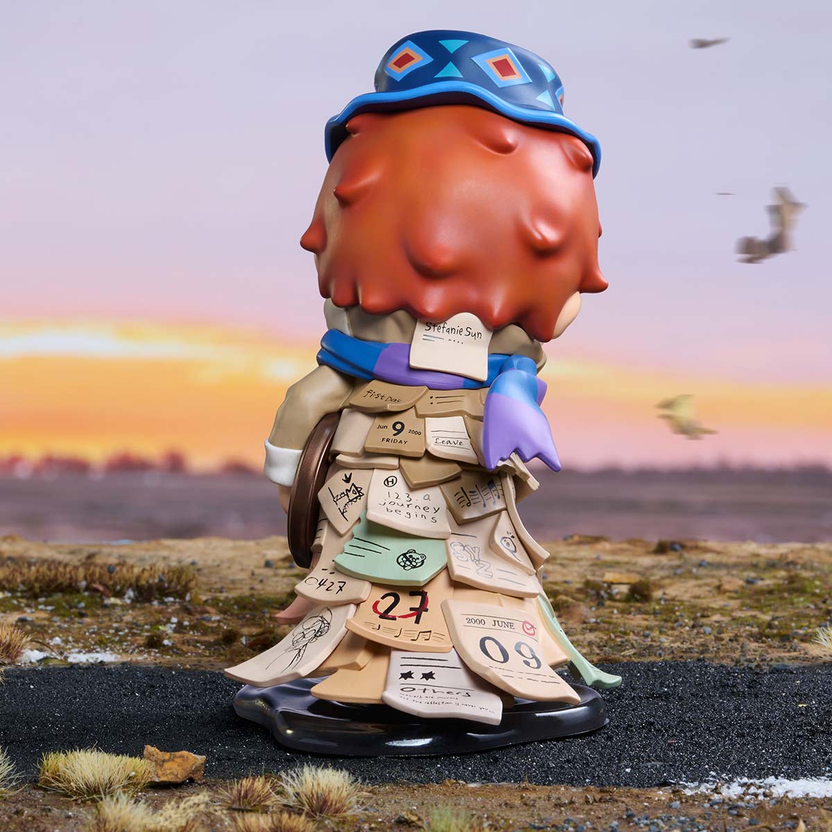 HIRONO x Stefanie Sun Weather With You figurine, rear view showing scarf and layered calendar-note coat
