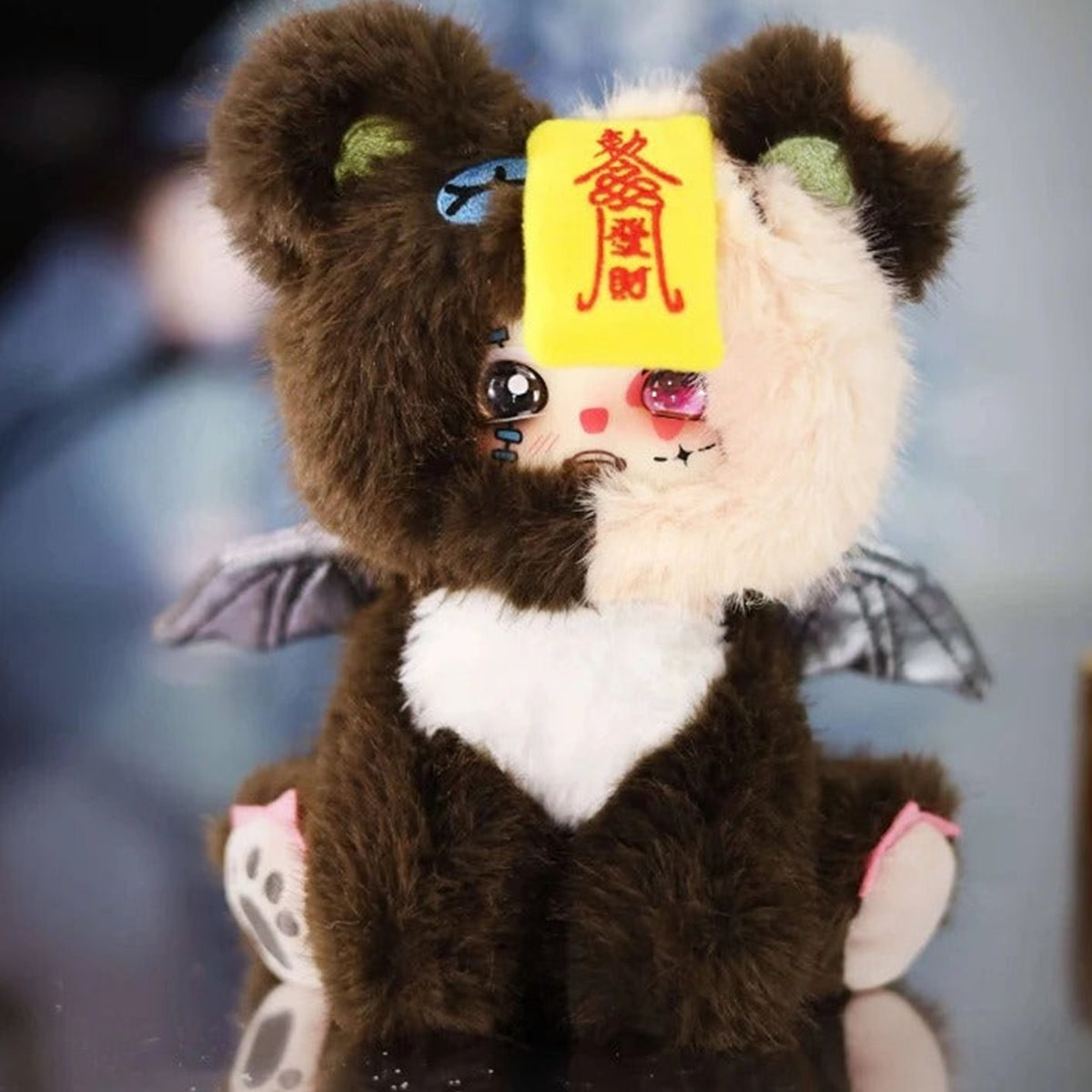 Brown LOKIKI plush with bat-wing and talisman details; series design example | KikiBuddies