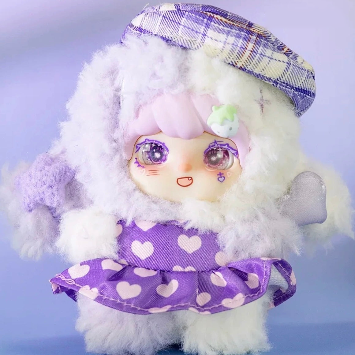 Lokiki Sweety2 plush doll design in a purple heart-patterned dress and checked hat, with headwear and feet visible; pictured design is not guaranteed in a random box.