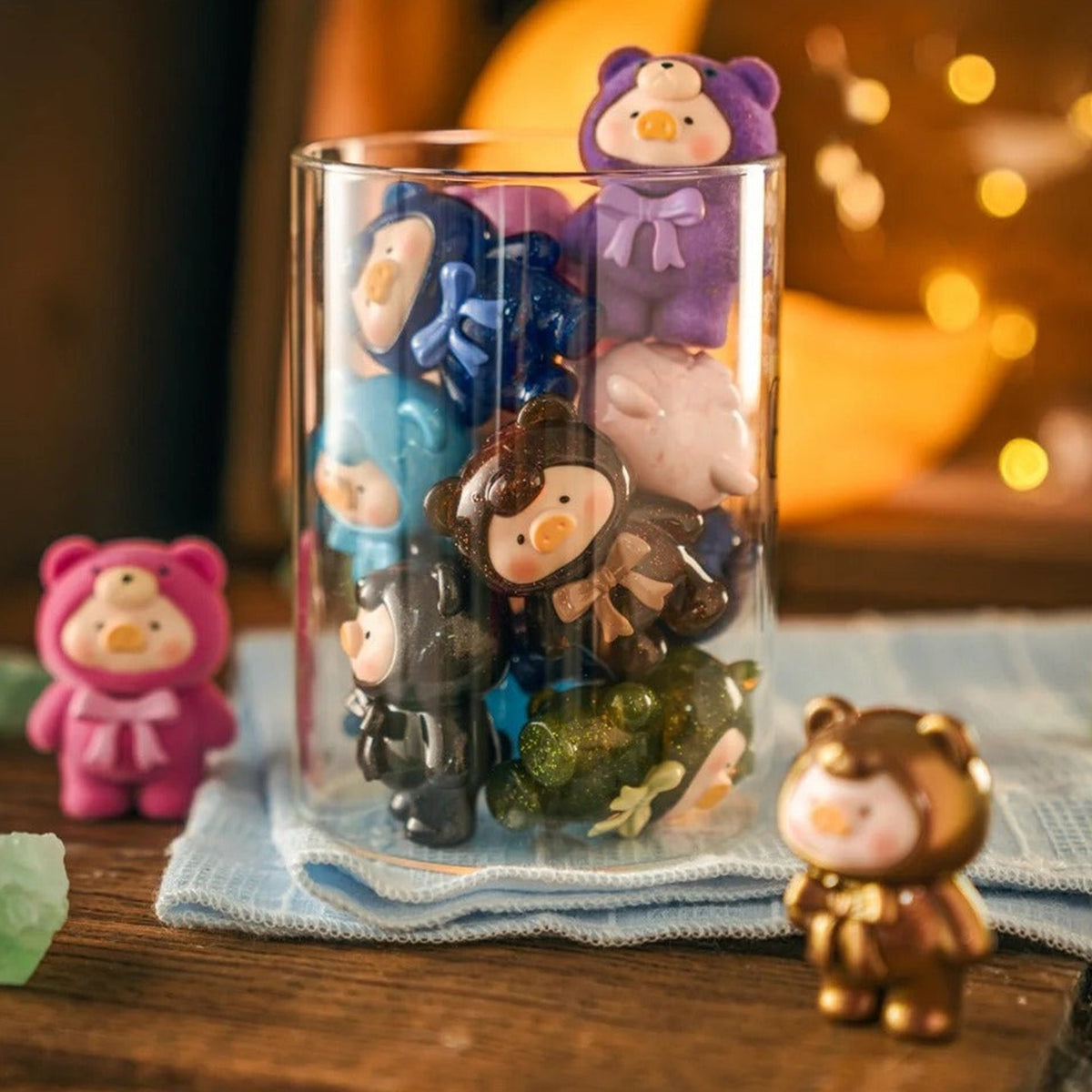 LuLu The PIGGY Teddy MINI figures in a styled display with a glass container; display accessories are not promised inclusions.
