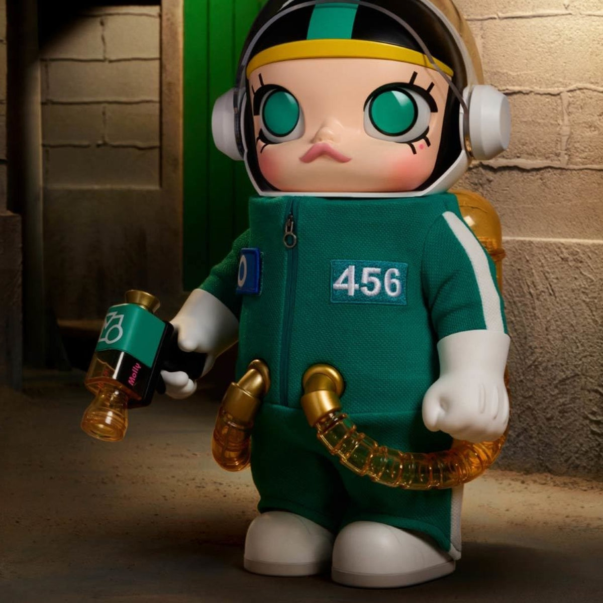 MEGA SPACE MOLLY 400% figure in a green tracksuit and helmet, shown in a display scene