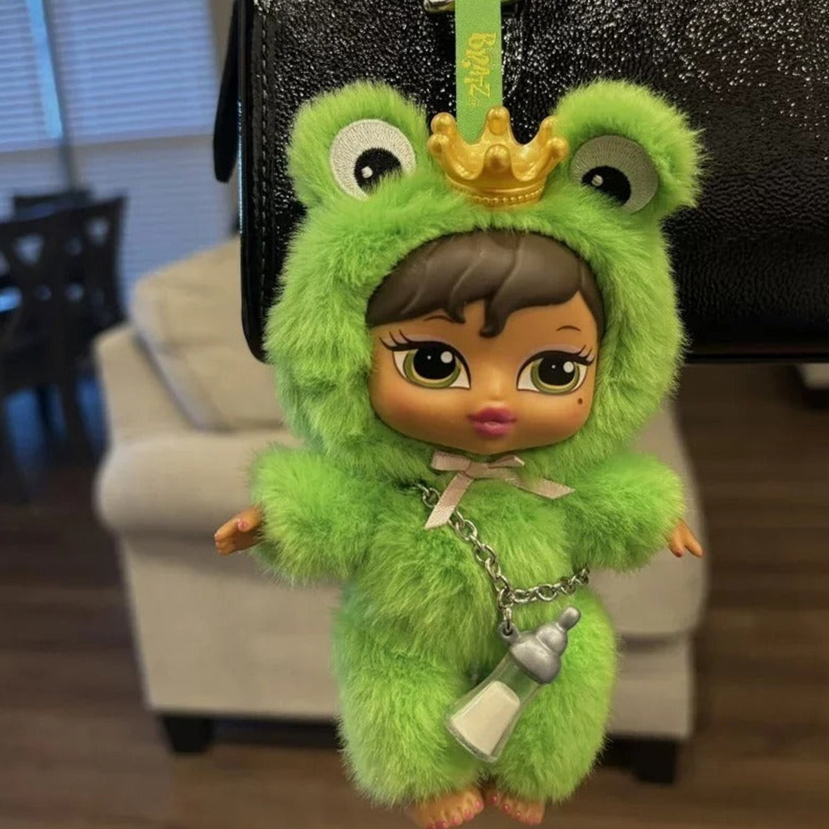 MGA Bratz Bratziez Iconz Series Plush Pendant Blind Box - Complete green frog-hood plush example; hanging strap extends beyond frame; random design not guaranteed