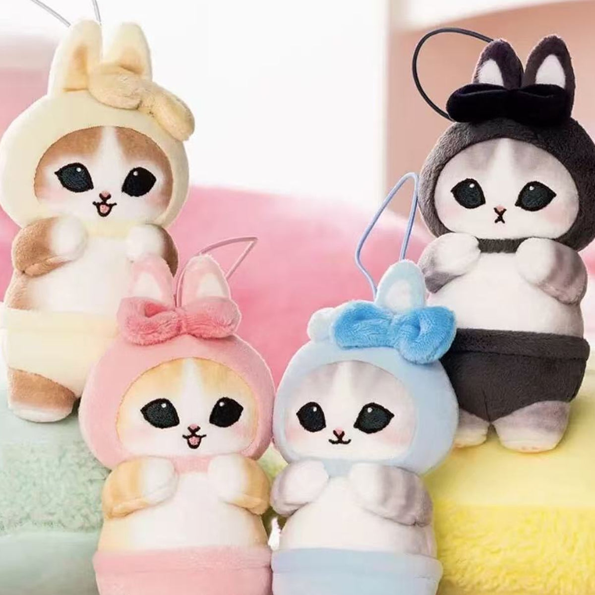Mofusand rabbit-outfit plush pendants in black, pink, yellow and blue shown together for color comparison; not a four-piece set