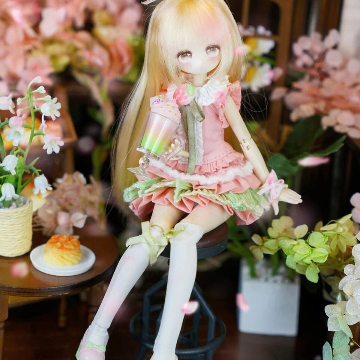 Momotale Four Seasons Tea Tales blonde doll in pink-and-green outfit, seated display detail; series example
