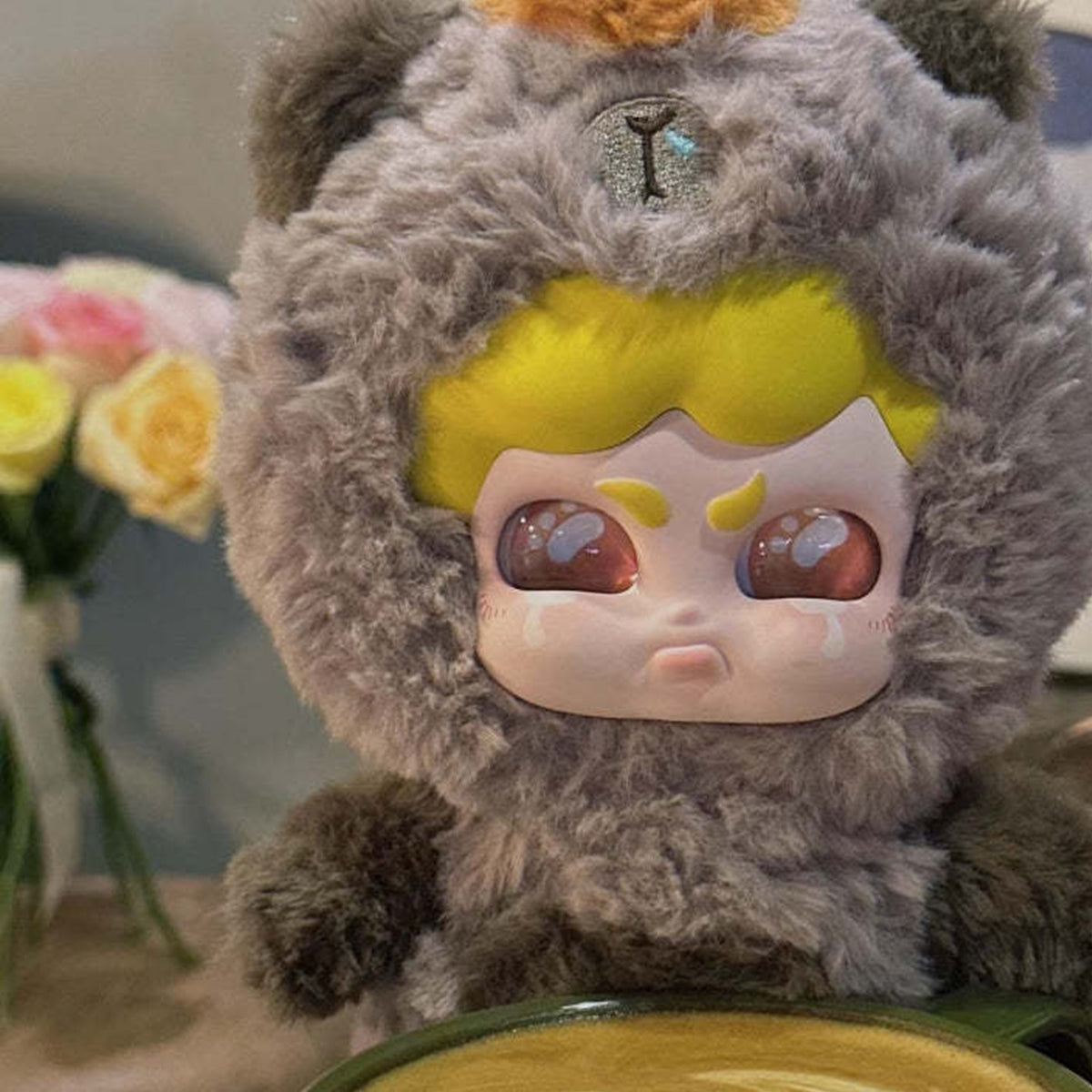 MUMU FOREST WHISPER Series Plush Dolls, Blind Box - Brown MUMU plush hood and face detail at a coffee table; upper tuft cropped and lower body obscured; random design not guaranteed; display props not included