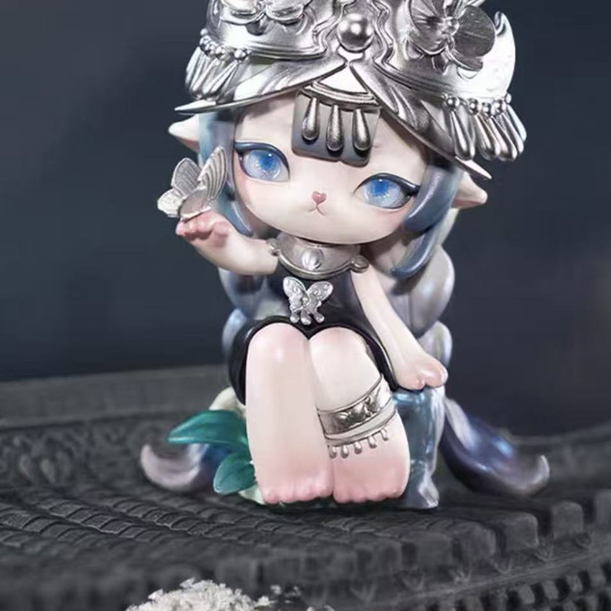 Ninimo Whispering Seasons Series Figure Blind Box - Blue-haired seated figure with silver-colored ornate headgear; upper headgear cropped; random design not guaranteed; display props not included