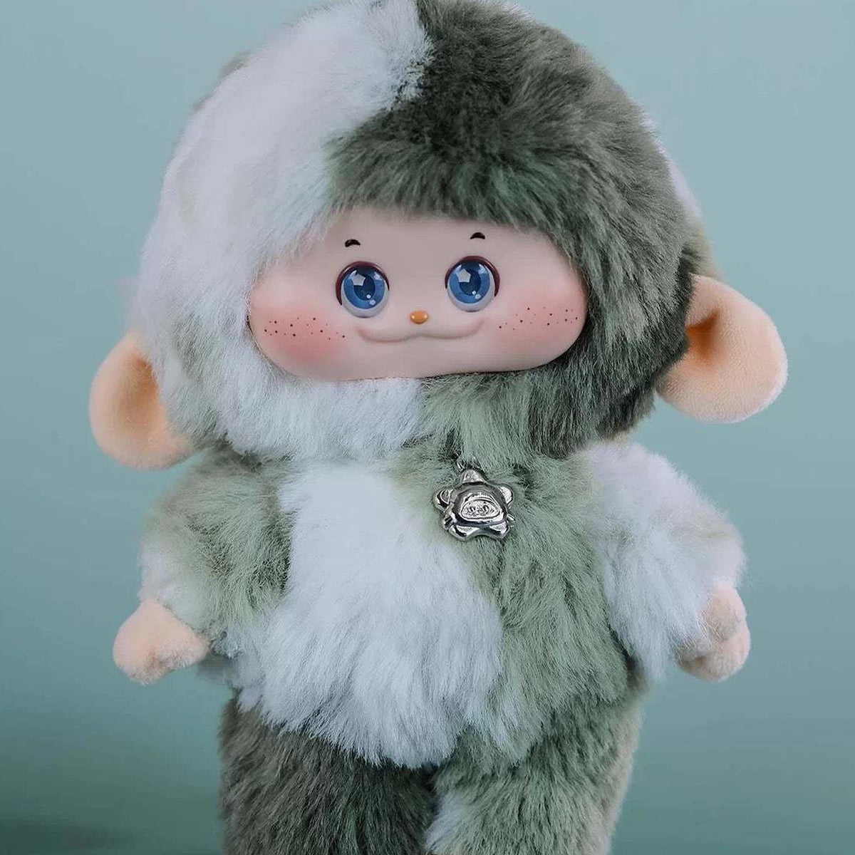 PIMOMO Vinyl Face Series Plush Dolls, Blind Box - Green-and-white PIMOMO vinyl-face plush detail with chest charm; lower feet cropped; random design not guaranteed; display props not included