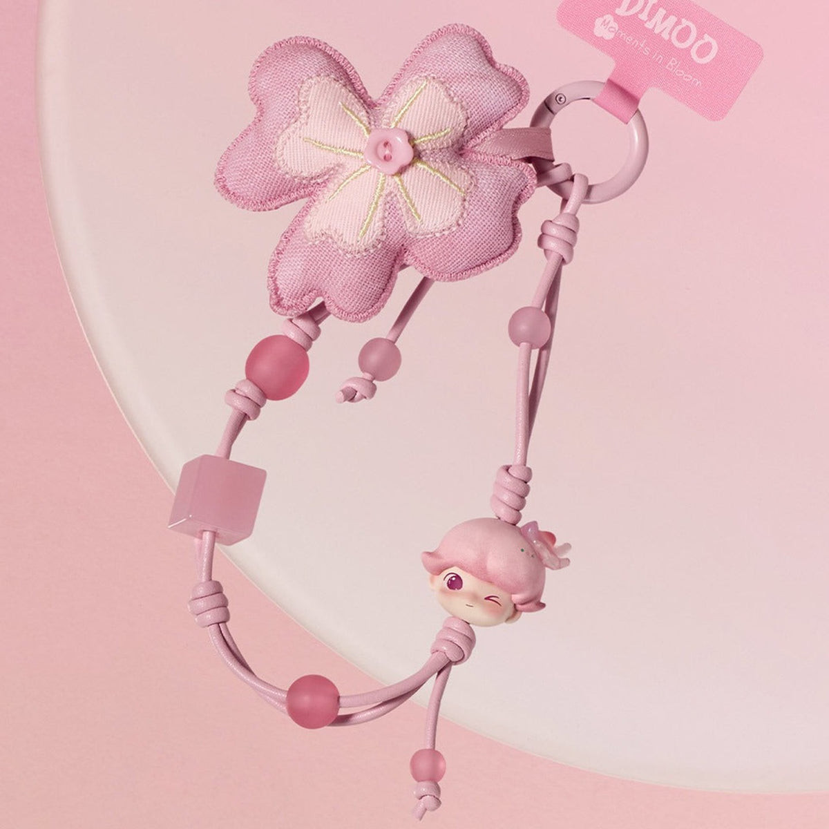 Pink flower DIMOO Moments in Bloom decorative charm, showing the loop, beads and hanging character.