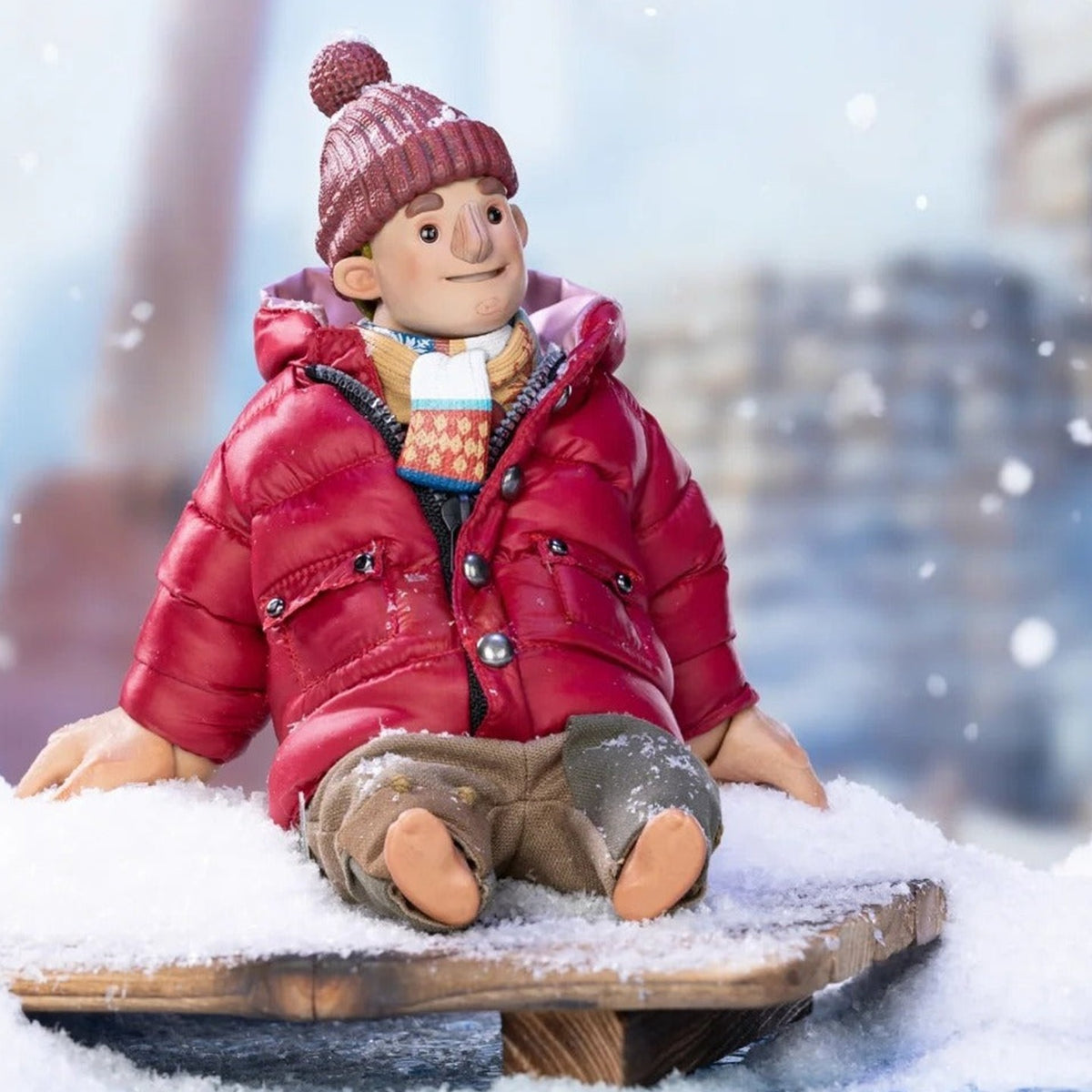 It Takes Two Winter Series Cody seated in a red winter jacket and knitted hat