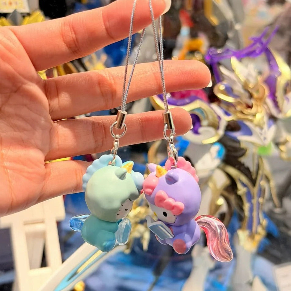 SANRl0 HK Dreamy Adventure Series Mini Figure Blind Box - Green and purple mini figure pendants with straps shown from rear angle; pictured design not guaranteed