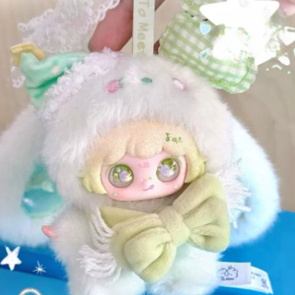 TOMEET Cuteness Accelerating Series Plush Pendant Blind Box - White plush design with green bow and patterned top accent; upper decoration cropped; random design not guaranteed; display props not included