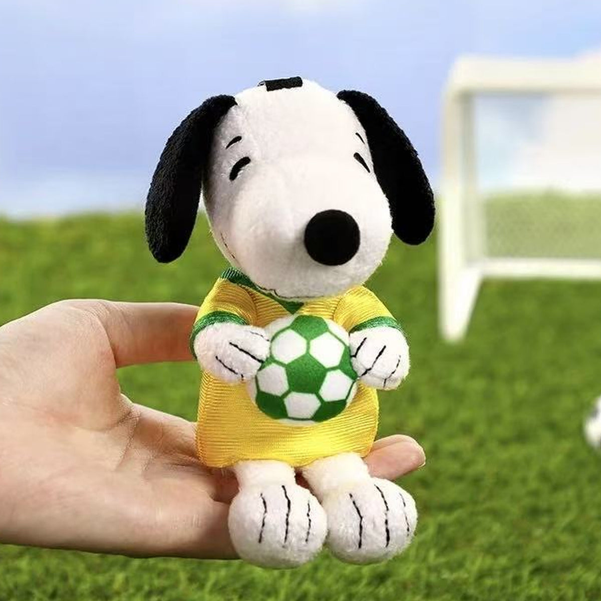 VIPO × PEANUTS Snoopy Football Series Plush Pendant Blind Box - Complete yellow football plush pendant example; hand used for scale; random design not guaranteed