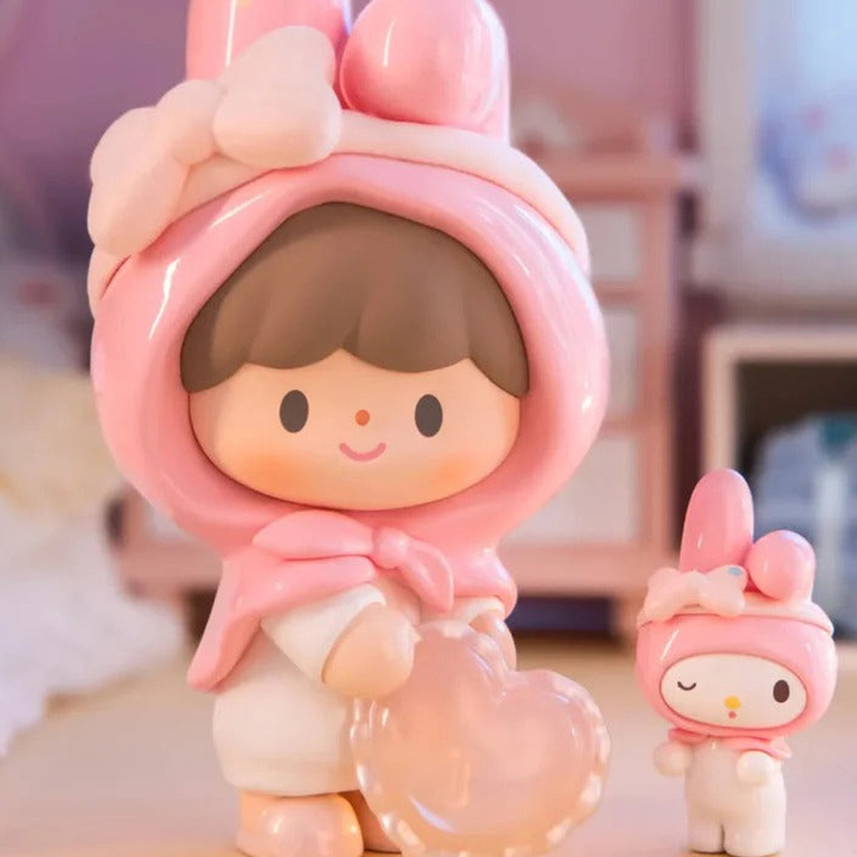 zZoton x Sanrio Preparation Before Bedtime Series Figures, Blind Box - Pink bunny-ear hood design holding a heart-shaped detail beside small matching character; upper ears cropped; random design not guaranteed; display props not included